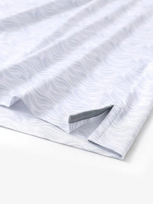 Hem slit detail of MAELREG Performance Jersey Print Polo in White Grey Sea Wave – comfort & movement