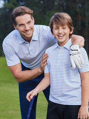 Adult and child models wearing white/light blue stripe popular yarn dyed stripe polo outdoors together.