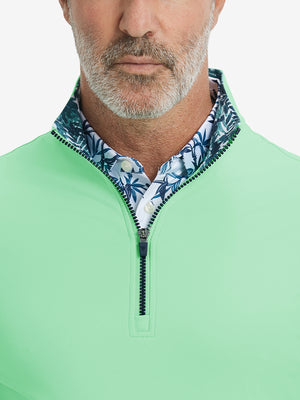 Close-up from nose to chest, showing collar and zipper detail of the light green golf pullover.