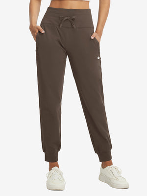 Model wearing women's stretch fleece lined water resistant joggers in coffee brown, showcasing the front lower body view.