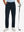 Lightweight moisture wicking dress pants in navy, front lower-body with model leaning on golf club.