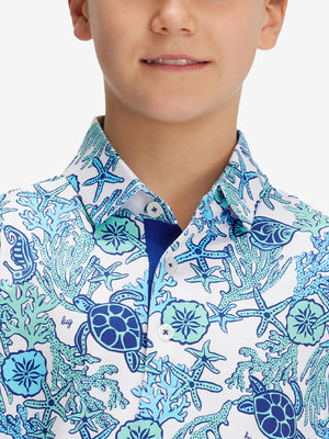 Close-up: nose to chest in sea turtle performance print boys golf polo.