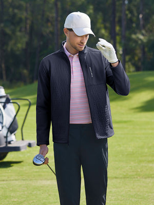 Model in black softshell water resistant lightweight jacket holding a golf club outdoors, half-body shot