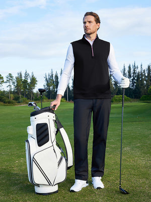Model holding a golf club beside a golf bag on course, wearing print collar quarter zip golf vest in black