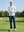 Model leaning on golf club on the course wearing full print lightweight quarter zip pullover in grey irregular shape