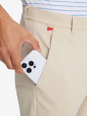Side pocket detail of Golf Lightweight Fleece Lined Dress Pants in light khaki, holding smartphone