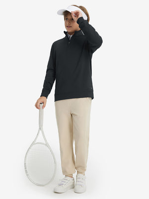 Model wearing a cap and holding a tennis racket, youth winter micro-fleece quarter zip pullover in black