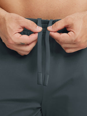Back pocket detail of Water Resistant Comfy Fleece Golf Joggers in dark grey, holding smartphone