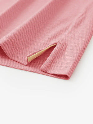 Hem slit detail of PINK HEATHER Premium Stretch Heather Polo highlighting stitching and finish.