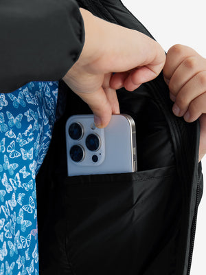 Close detail of hands inside pockets of boys windproof puffer jacket with pockets in black.