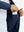 Hand placing iPhone into inner pocket of lightweight water-resistant outerwear jacket in blue indigo