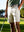 Outdoor shot of a model's lower body holding a golf club, wearing the beige water resistant golf shorts with a relaxed fit
