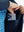 Close detail of hands inside pockets of boys windproof puffer jacket with pockets in dark blue.