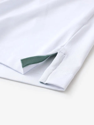 Hem slit detail of WHITE Moisture Wicking Color Block Polo Shirt highlighting stitching and finish.