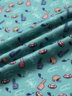 Close-up of green rugby performance print boys golf polo fabric showing moisture-wicking texture and vibrant pattern.