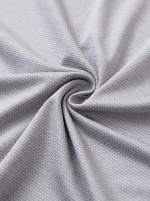 Close-up of faded denim heather ventilated heather jacquard polo fabric showing breathable texture and subtle pattern details.