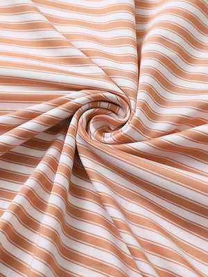 Close-up of orange white yarn dyed stripe polo fabric showing distinct woven stripes and textured surface.