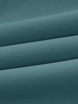 Close-up of wrinkle-resistant, sun-protective fabric on water-resistant golf stretch nylon pants in dark teal.