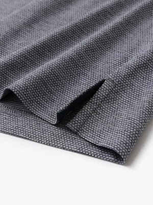 Close-up of side hem slit on Ventilated Heather Jacquard Polo in NAVY HEATHER, showing detail