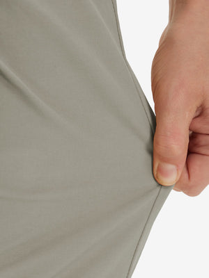 Action shot demonstrating the stretch of the khaki grey youth water resistant cotton blend golf pants for active movement